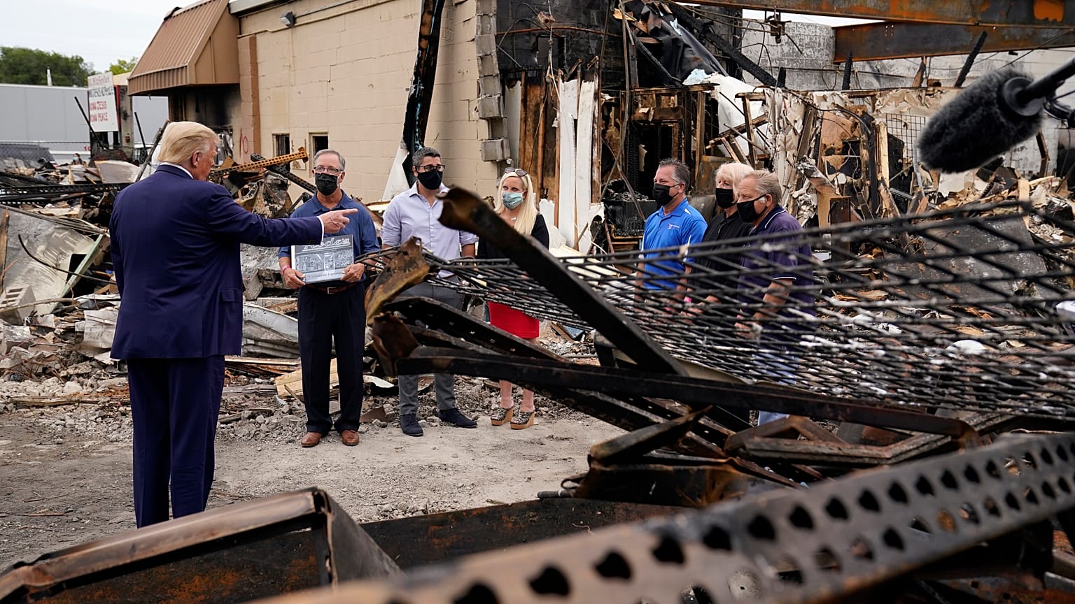 President Donald Trump talks to business owners Tuesday, Sept. 1, 2020, as he tours an area damaged during demonstrations after a police officer shot Jacob Blake in Kenosha.