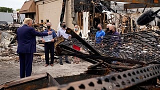President Donald Trump talks to business owners Tuesday, Sept. 1, 2020, as he tours an area damaged during demonstrations after a police officer shot Jacob Blake in Kenosha.