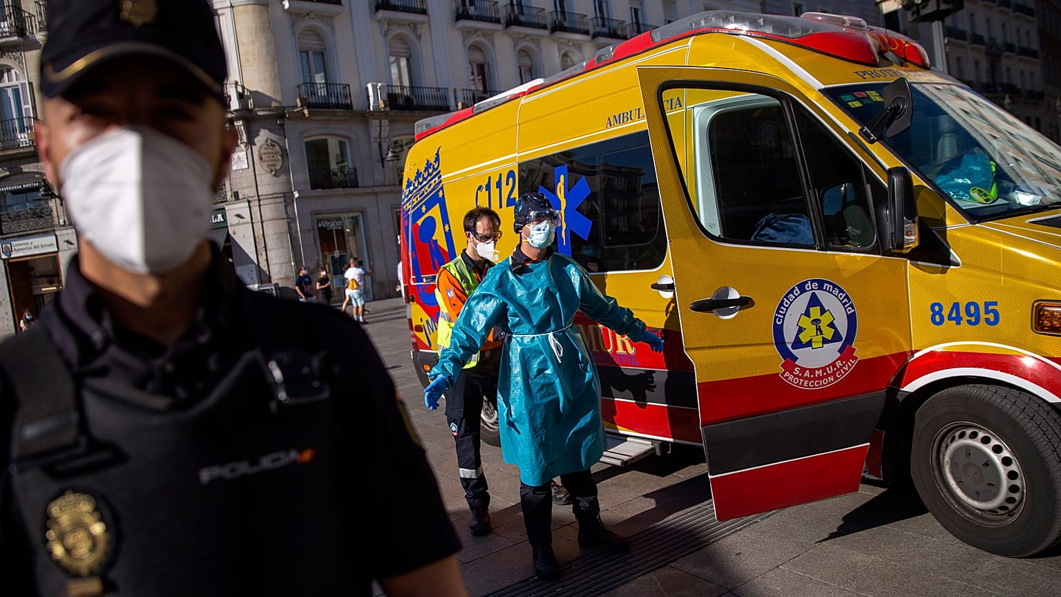 A health worker in personal protection equipment is disinfected by a another health worker at the Puerta del Sol in Madrid, Spain, Friday, Aug. 28, 2020.