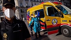 Un trabajador sanitario es desinfectado por un compañero en la madrileña Puerta del Sol