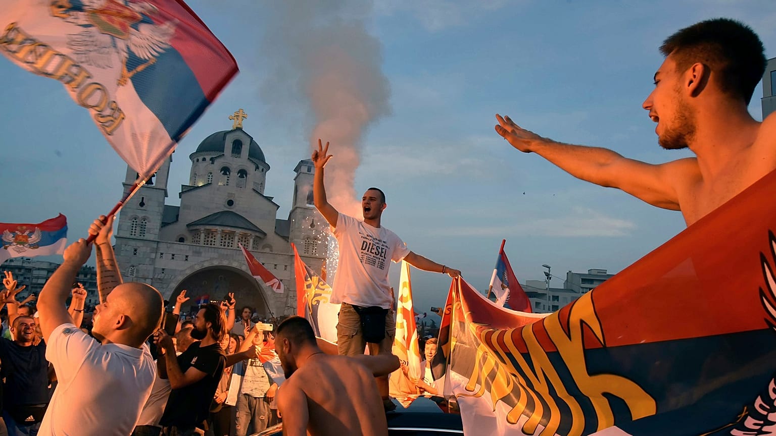 Opposition supporters celebrate the election results outside the Serbian Orthodox Church of Christ's Resurrection in Podgorica, Montenegro.