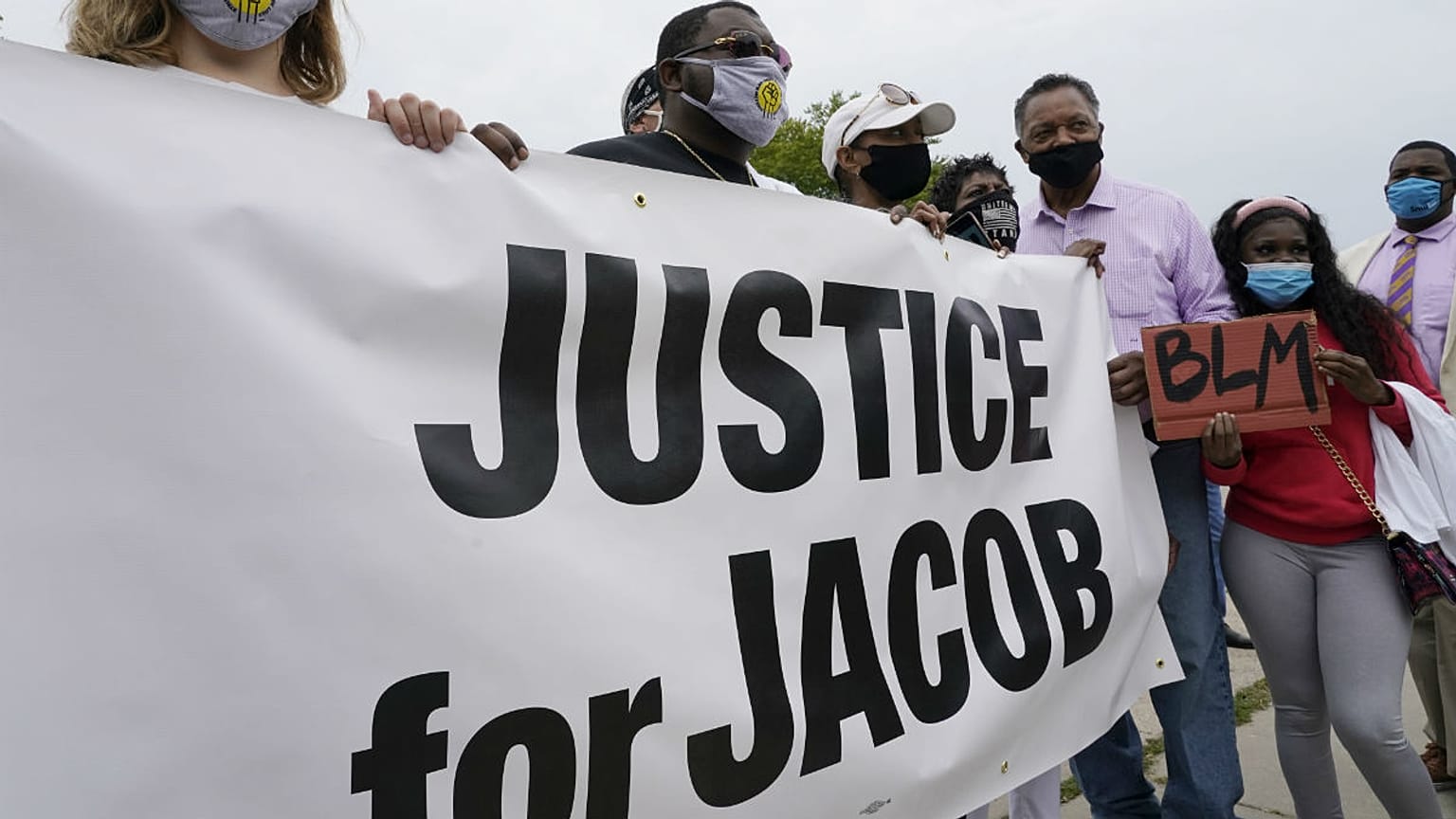The Rev. Jesse Jackson, third from right, pauses for a photo during a community gathering at the site of Jacob Blake's shooting Tuesday, Sept. 1, 2020, in Kenosha