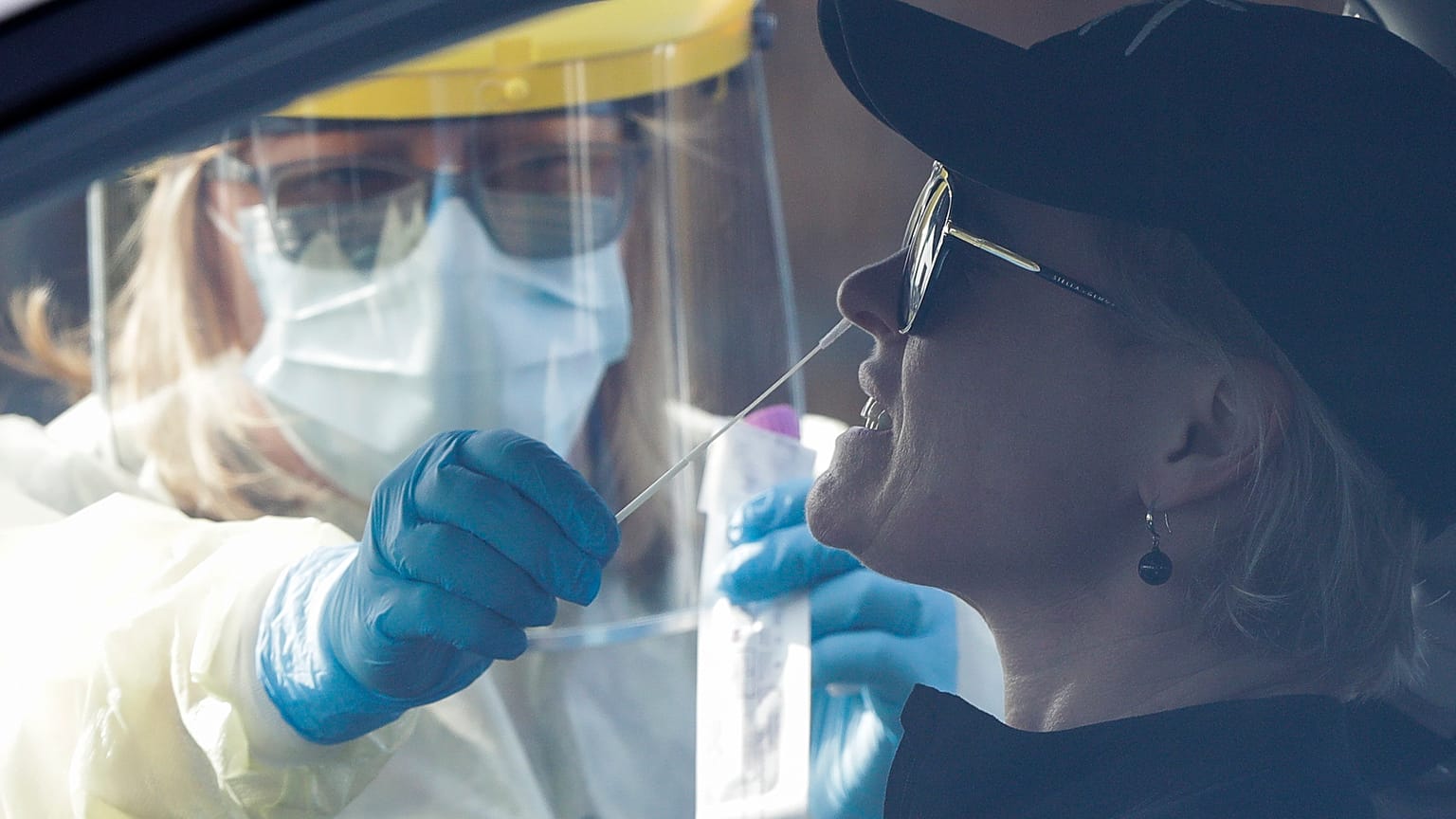 Medical staff take a COVID-19 test from a visitor to a drive through community based assessment centre in Christchurch, New Zealand, Thursday, Aug. 13, 2020.