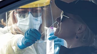 Medical staff take a COVID-19 test from a visitor to a drive through community based assessment centre in Christchurch, New Zealand, Thursday, Aug. 13, 2020.
