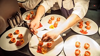 A chef dressing a plate of 3D-printed food by the Foodini machine.