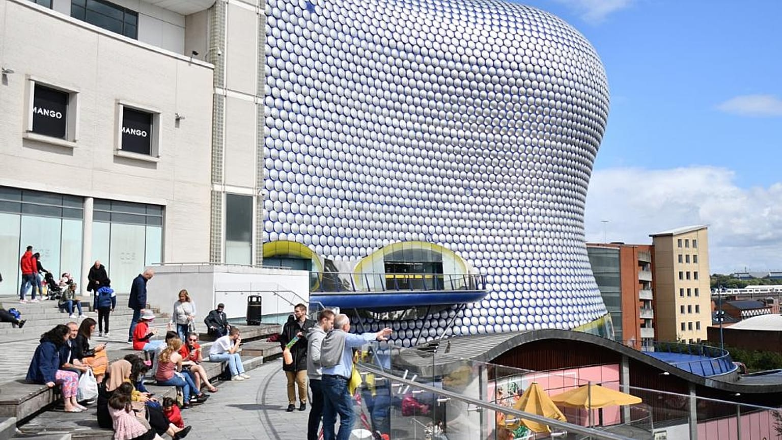 Birmingham'daki Bullring alışveriş merkezinin önünde oturan insanlar (Arşiv)