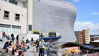 Birmingham'daki Bullring alışveriş merkezinin önünde oturan insanlar (Arşiv)