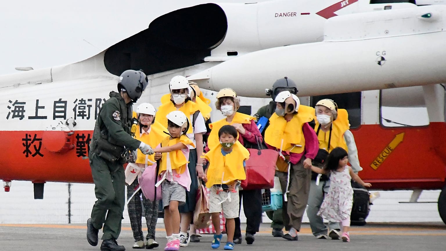 Residents arrive at a heliport in Kagoshima, southern Japan Friday, Sept. 4, 2020, to take refuge ahead of a powerful typhoon.
