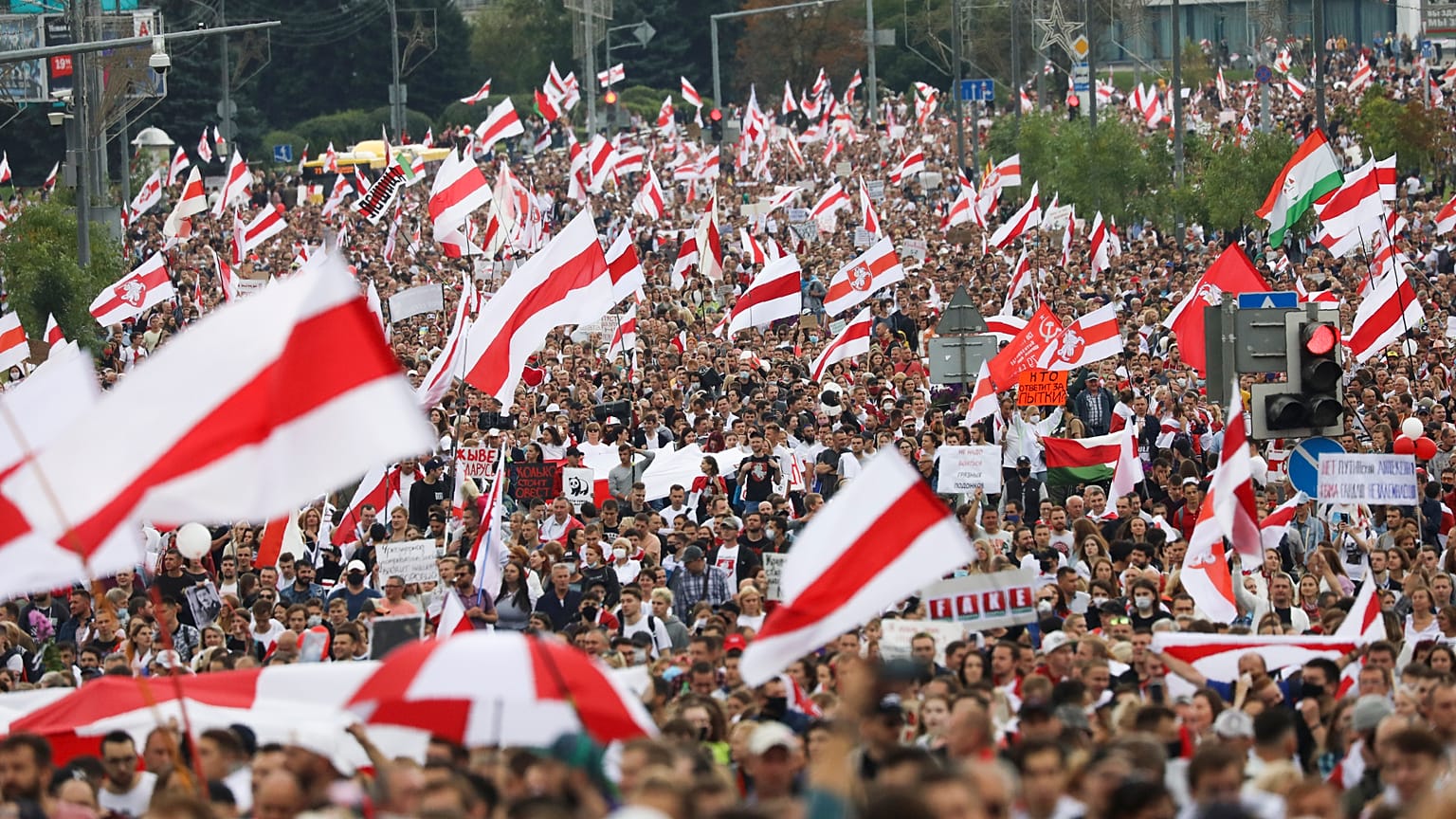 Crowds of protesters carry former Belarusian national flags during an opposition rally to protest the official presidential election results in Minsk, Belarus. Sept. 6, 2020.