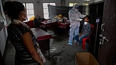 An Indian health worker takes a nasal swab sample of a man to test for COVID-19 as a woman waits for her turn in Gauhati, India, Sunday, Sept. 6, 2020.