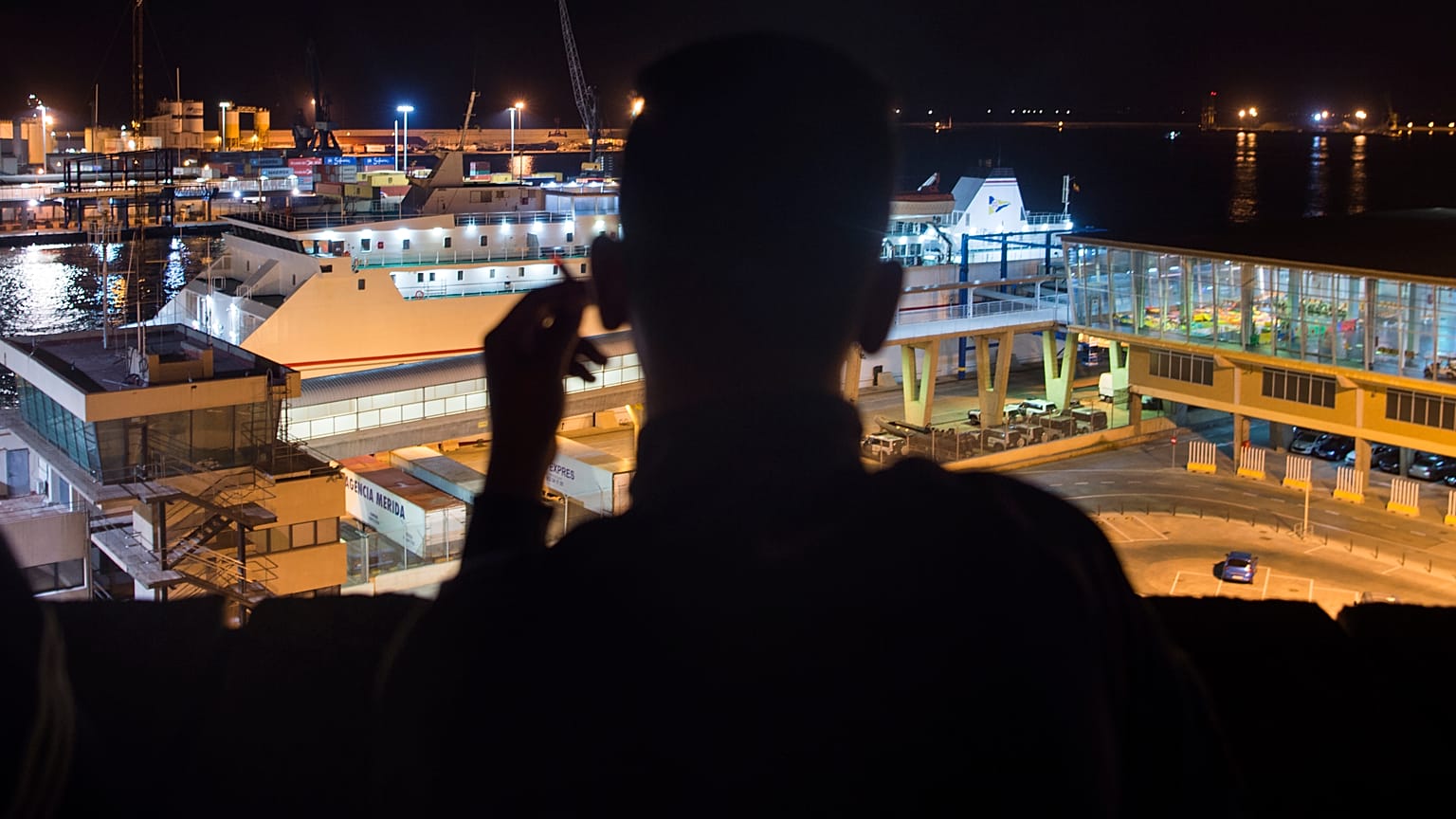 Un senzatetto marocchino guarda il porto di Melilla in una sera di settembre del 2018 - Foto d'archivio