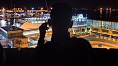 Un senzatetto marocchino guarda il porto di Melilla in una sera di settembre del 2018 - Foto d'archivio