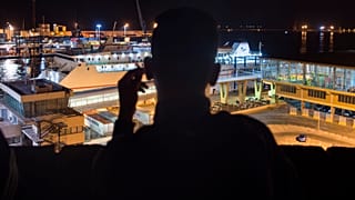 Un senzatetto marocchino guarda il porto di Melilla in una sera di settembre del 2018 - Foto d'archivio