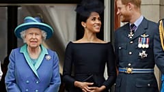 Britain's Queen Elizabeth II, Meghan and Harry watch a flypast of Royal Air Force aircraft pass over Buckingham Palace in London