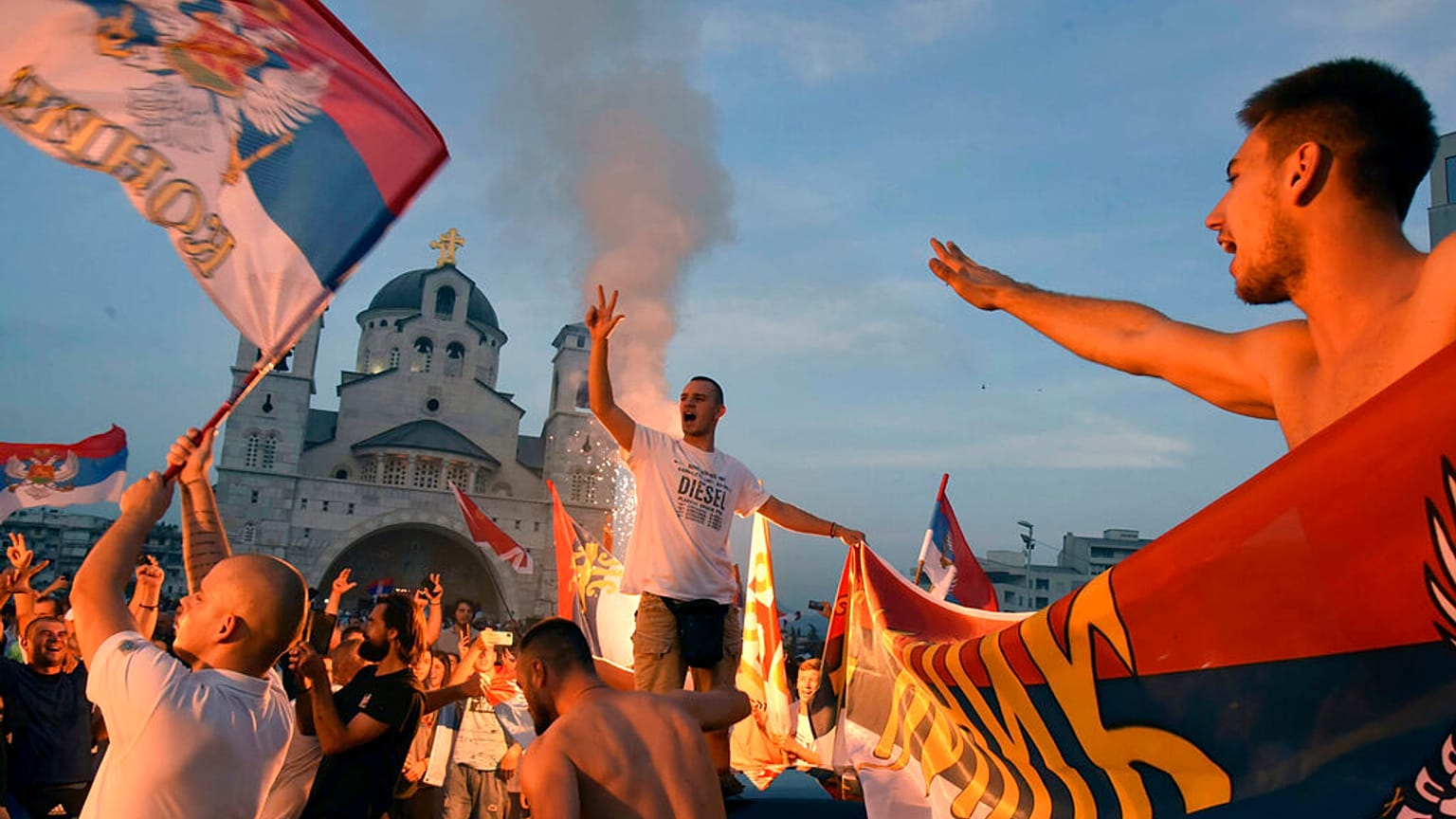 Opposition supporters celebrate after the parliamentary elections in front of the Serbian Orthodox Church of Christ's Resurrection in Podgorica, Montenegro, Monday, Aug. 31