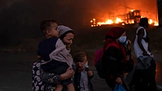 Migrants flee from the Moria refugee camp during a second fire, on the northeastern Aegean island of Lesbos, Greece, on Wednesday, Sept. 9, 2020. F
