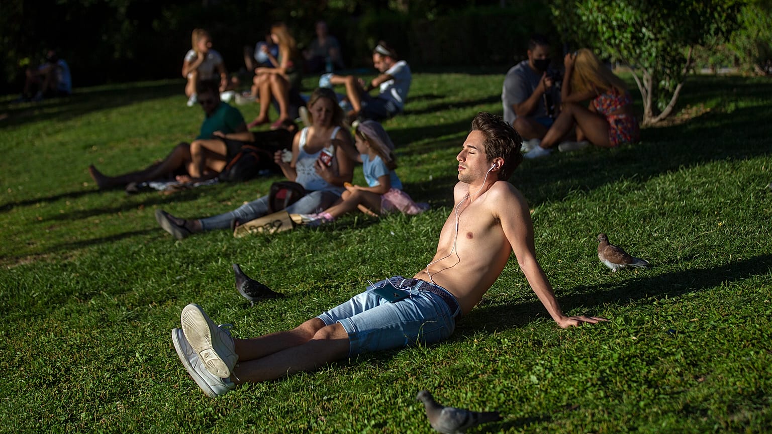 La gente toma el sol en el parque del Retiro en Madrid, España, el viernes 28 de agosto de 2020.