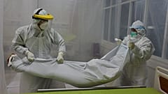 Des agents hospitaliers prenant en charge le corps d'un patient ayant succombé de la Covid-19 dans un hôpital de Bogor en Indonésie, le 9 septembre 2020