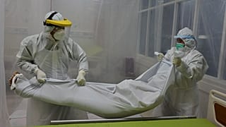 Des agents hospitaliers prenant en charge le corps d'un patient ayant succombé de la Covid-19 dans un hôpital de Bogor en Indonésie, le 9 septembre 2020