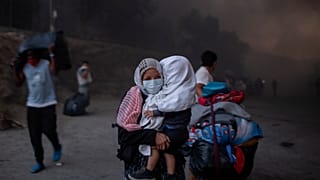 Migranten verlassen brennendes Camp Moria.