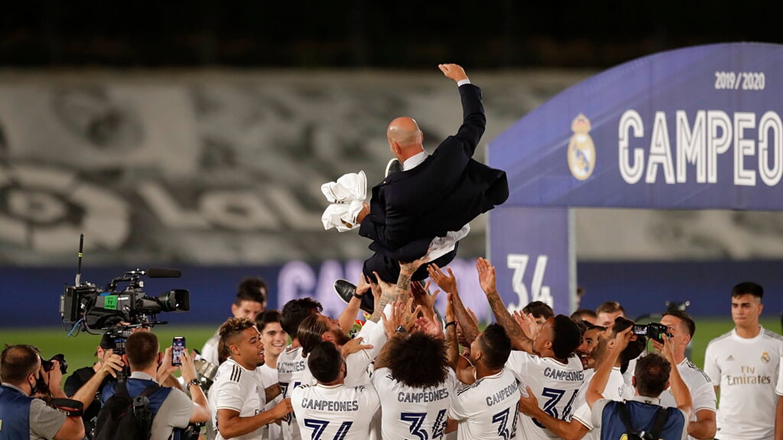 Real Madrid's players throw on the air their head coach Zinedine Zidane, as they celebrate after winning the Spanish La Liga 2019-2020 