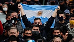 Un policía bonaerense alza una bandera de Argentina durante las protestas