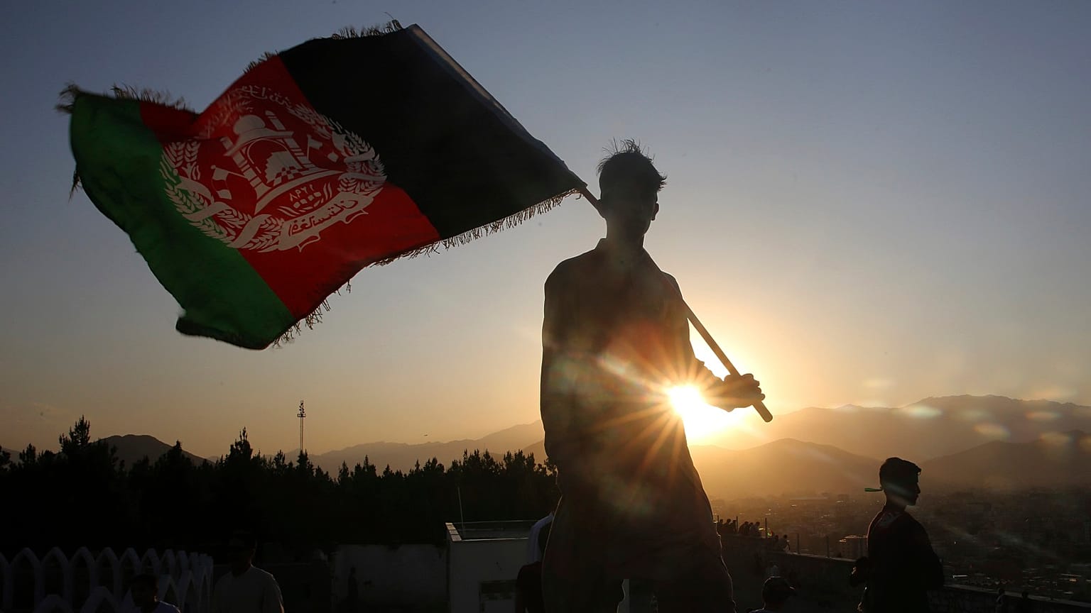 a man waves an Afghan flag during Independence Day celebrations in Kabul, Afghanistan.