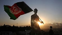 a man waves an Afghan flag during Independence Day celebrations in Kabul, Afghanistan.