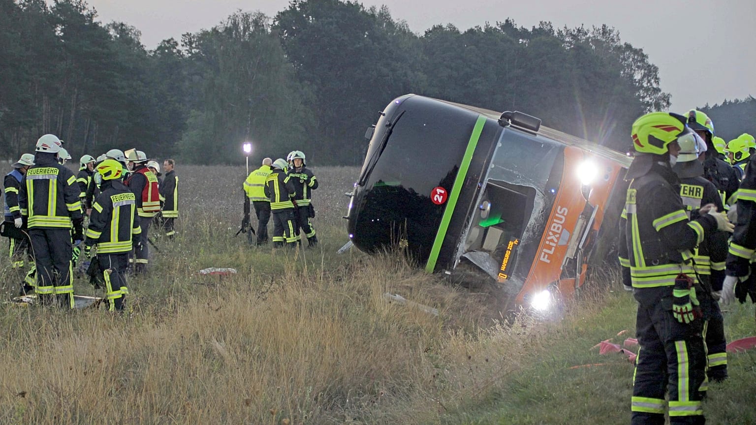 Firefighters are standing next to a long-distance bus on the A24 motorway in Woebbelin, northern Germany.