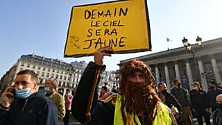 Bir sarı yelekli Paris'te elinde "Yarın gök yüzü sarı olacak" pankartı ile gösteriye katıldı