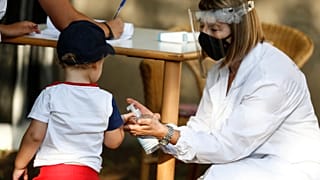 Νοσηλεύτρια βάζει αντισηπτικό στο χεράκι παιδιού στην Ιταλία
