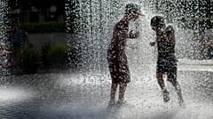 Lithuanian children cool off in a public fountain in Vilnius, Lithuania, Friday, June 19, 2020.