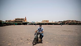 Un homme traverse la place Jemma el-Fnaa à Marrakech au Maroc d'habitude noire de monde, le 22 juillet 2020