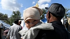 Mann hält Baby im Arm, Moria, Lesbos, 25.9.2020
