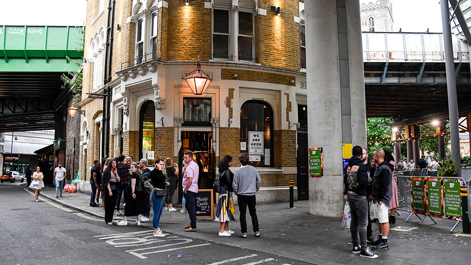 People sit and drink, outside a pub at Borough Market, as the capital is set to reopen after the lockdown due to the coronavirus outbreak, in London, Saturday, July 4, 2020.
