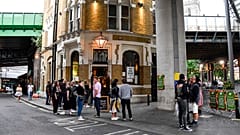 People sit and drink, outside a pub at Borough Market, as the capital is set to reopen after the lockdown due to the coronavirus outbreak, in London, Saturday, July 4, 2020.