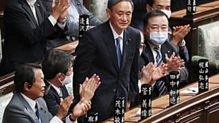 Yoshihide Suga stands up after being elected as Japan's new prime minister at parliament's lower house in Tokyo, Wednesday, Sept. 16, 2020.