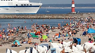People enjoy the unusually warm late summer weather on the Baltic Sea beach in Warnemuende, Germany