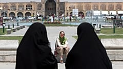 İran'ın İsfahan kentinde bir yabancı turistin önünden geçen çarşaflı İranlı kadınlar (arşiv)