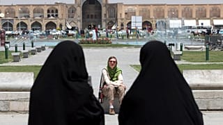 İran'ın İsfahan kentinde bir yabancı turistin önünden geçen çarşaflı İranlı kadınlar (arşiv)
