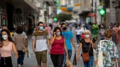 Personas con mascarilla caminan por una calle de Madrid