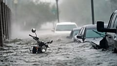 Cars and a motorcycle are underwater as water floods a street, in Pensacola, Fla., Wednesday, Sept. 16, 2020
