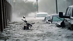 Cars and a motorcycle are underwater as water floods a street, Wednesday, Sept. 16, 2020, in Pensacola, Fla. Hurricane Sally made landfall Wednesday near Gulf Shores, Alabama.