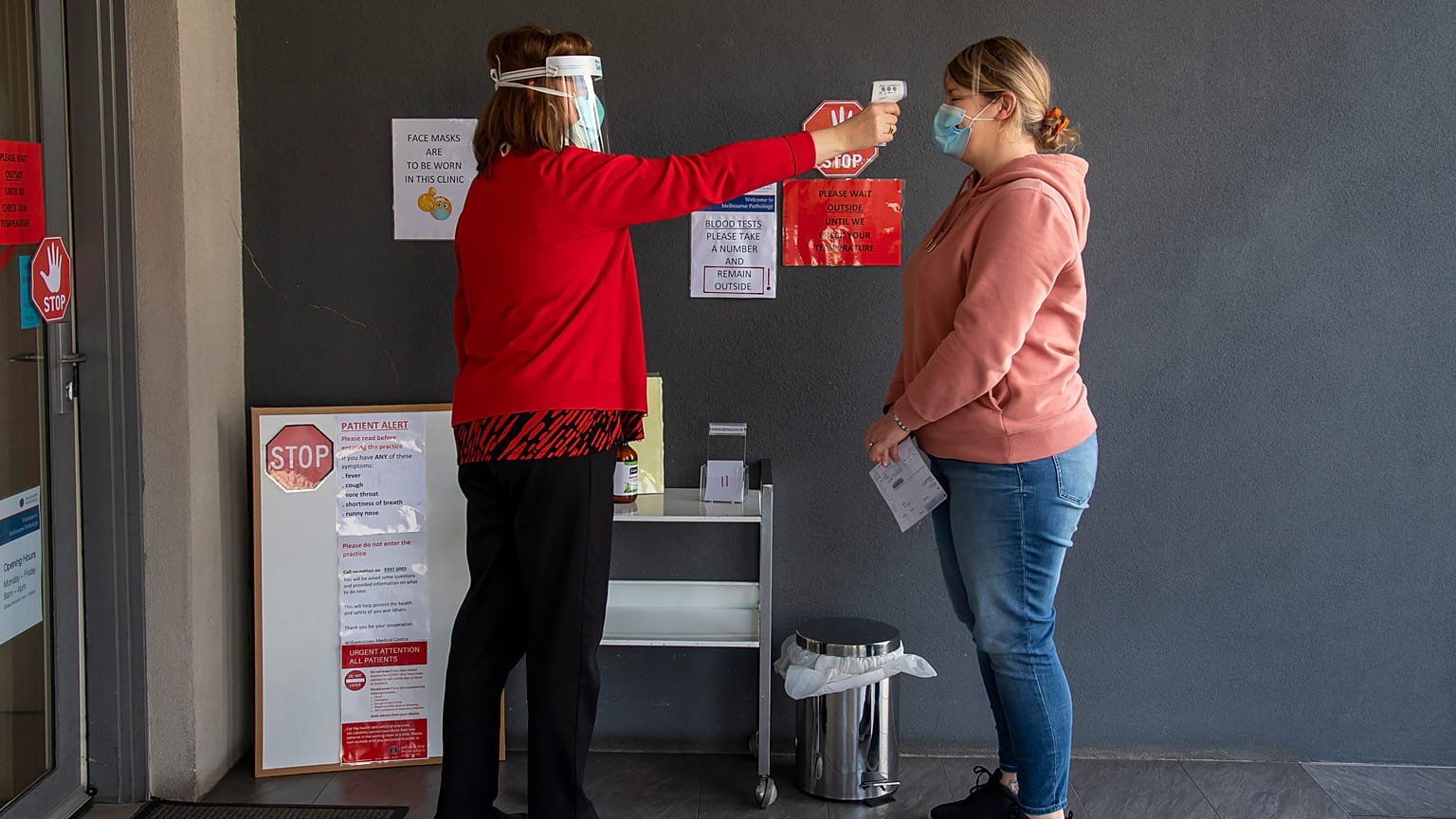 Una paciente se toma la temperatura en una clínica médica durante el confinamiento debido a la continua propagación del coronavirus en Melbourne, el jueves 6 de agosto de 2020