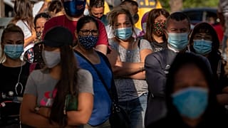 People wearing face masks wait their turn to be called for a PCR test for the COVID-19 in Barcelona, Spain on Monday Aug. 31, 2020.