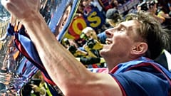 In this June 6, 2015 file photo, Barcelona's Lionel Messi smiles to his mirror in the trophy after winning the Champions League final football match against Juventus.