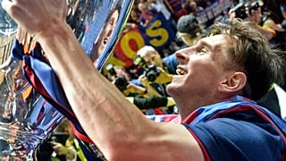In this June 6, 2015 file photo, Barcelona's Lionel Messi smiles to his mirror in the trophy after winning the Champions League final football match against Juventus.