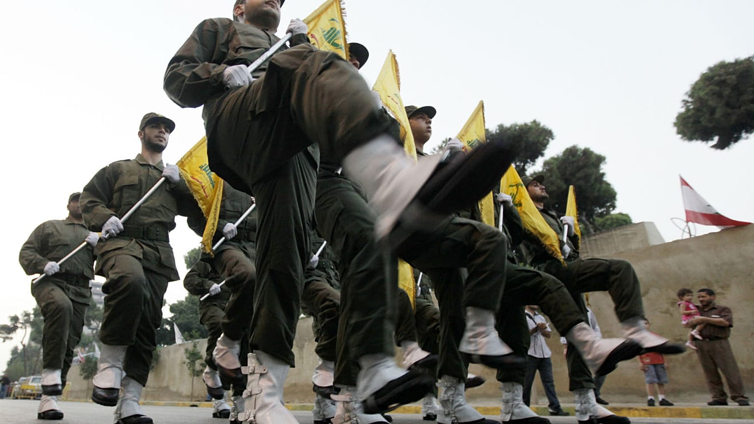 İsrail'le savaşta hayatını kaybeden Hizbullah üyeleri için kurulan yeni mezarın açılış töreninde yürüyen örgüt üyeleri (arşiv)