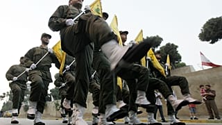 İsrail'le savaşta hayatını kaybeden Hizbullah üyeleri için kurulan yeni mezarın açılış töreninde yürüyen örgüt üyeleri (arşiv)