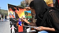 لاجئة أفغانية ترسم ذكريات عاشتها خلال حريق طال مخيمات اللاجئين